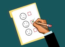 Fragebogen mit drei Gesichtern: neutral, glücklich, traurig. Hand kreuzt das glückliche Gesicht an.